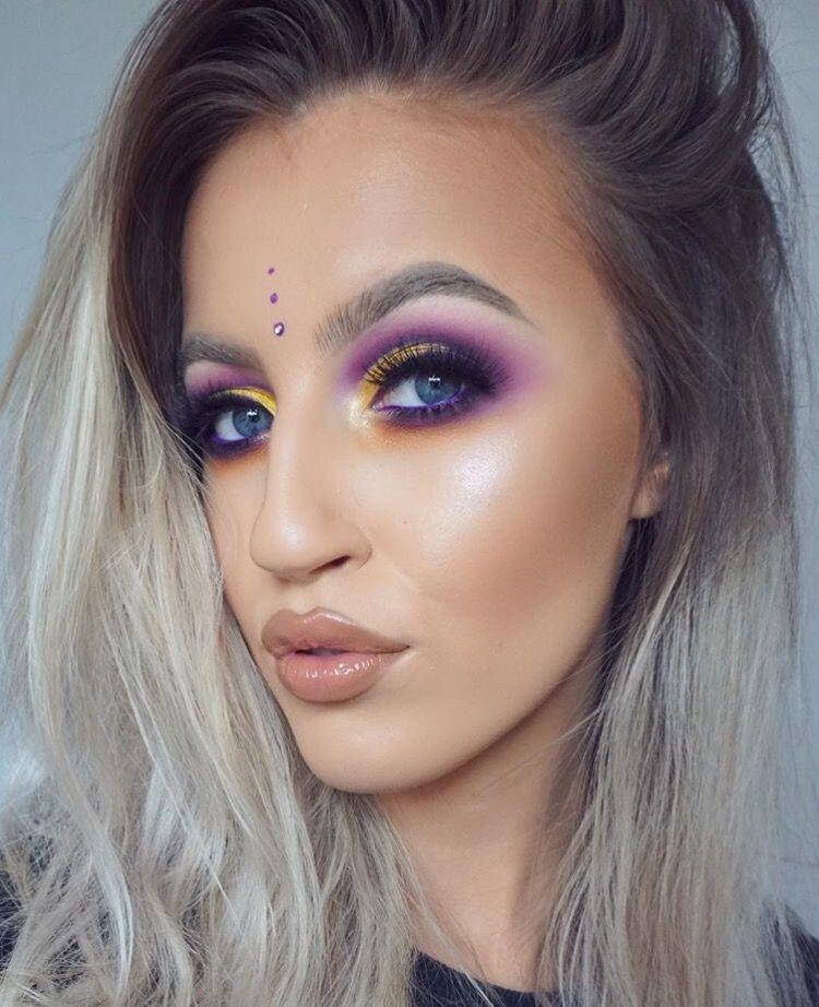 An image of girl showing her festival makeup using bright eyeshadow colours