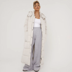 lady wearing grey joggers, white top and stone maxi puffer coat with button front